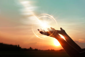 Woman hands praying for blessing from god on sunset background